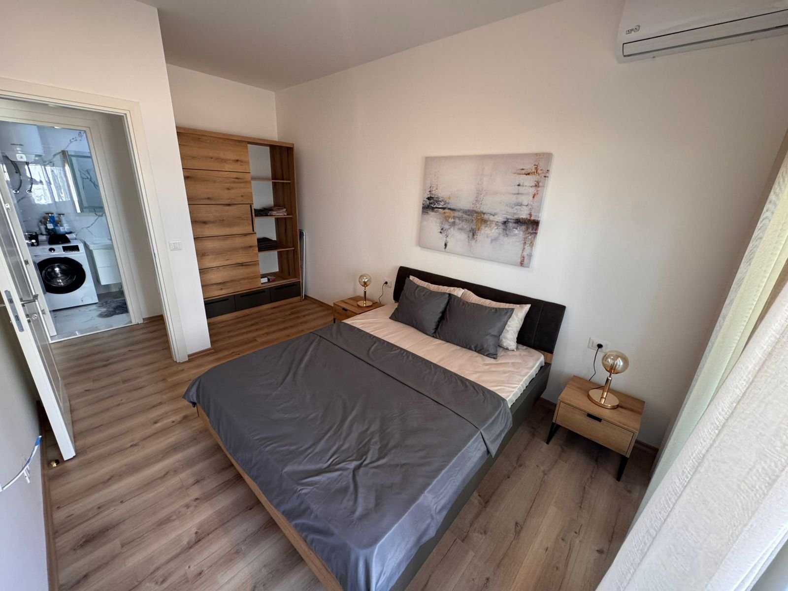 Modern Ulcinj bedroom with double bed, gray decor, wood accents, laundry area&mdash;prime eco-friendly property by ekosphere doo.