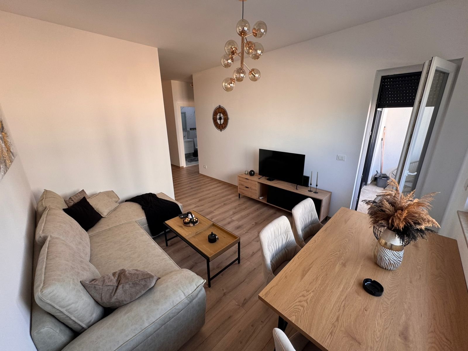 Modern Ulcinj living room with beige sofa, dining area, balcony access; prime property on immorenta.me by Ekosphere DOO.