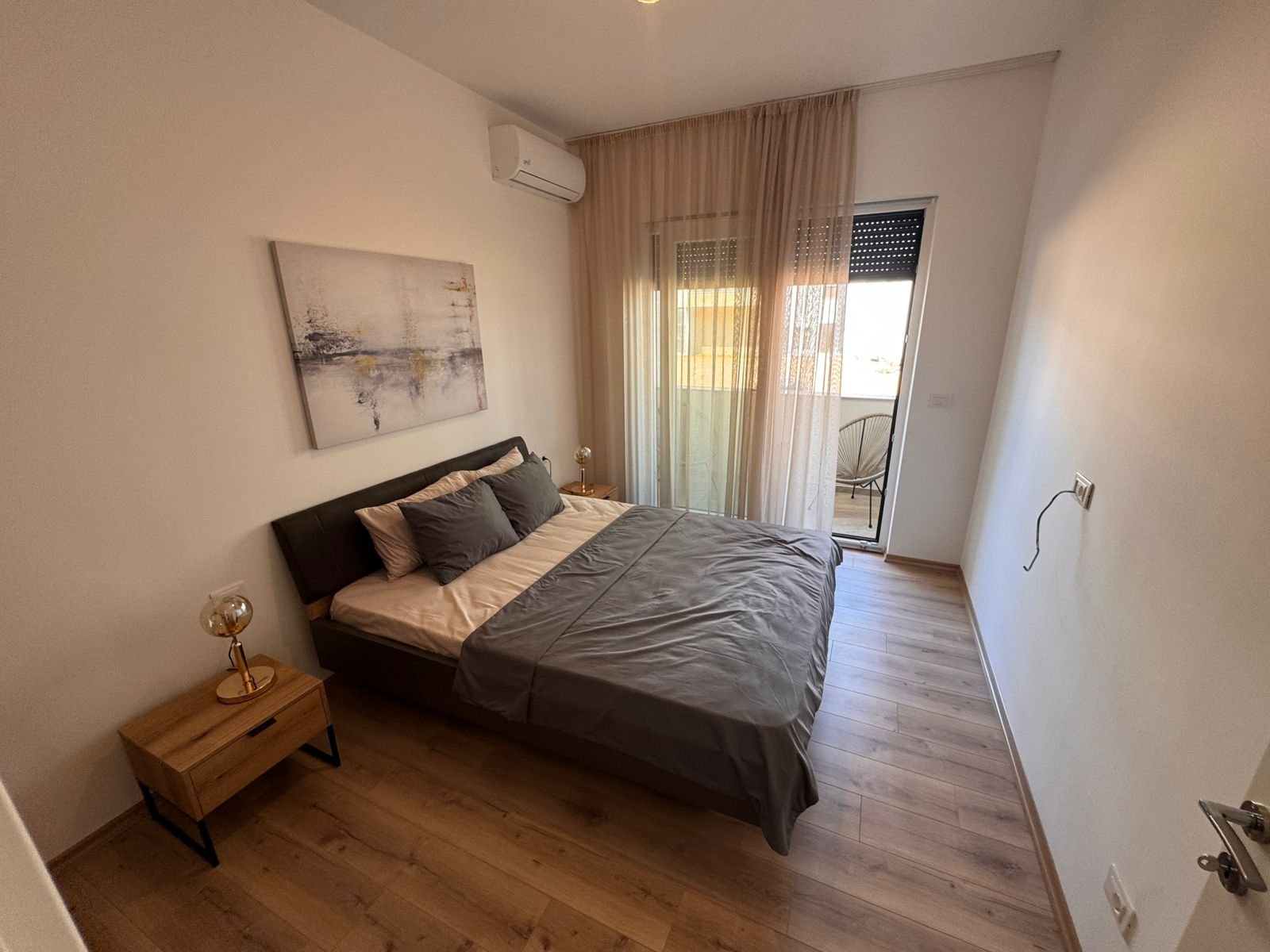 Stylish Ulcinj bedroom with gray bedding, wood accents, balcony & modern amenities; exclusive listing on immorenta.me by ekosphere doo.