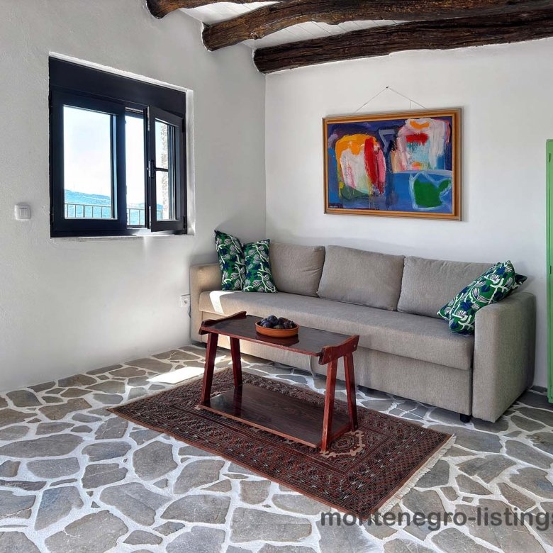 Listings for Sale - Elegant Ulcinj living room with gray sofa, stylish decor, beams; ideal Montenegro investment on immorenta.me by Ekosphere.