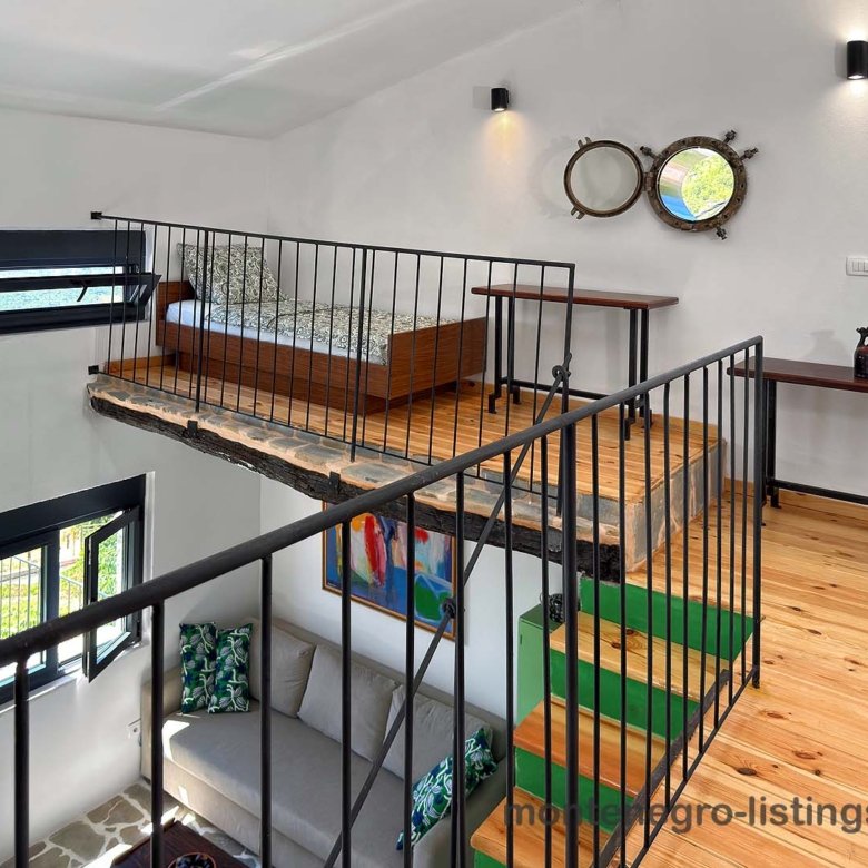 Modern loft bedroom with wood floors, metal railing, and dual mirrors, ideal Ulcinj investment at immorenta.me by ekosphere doo.