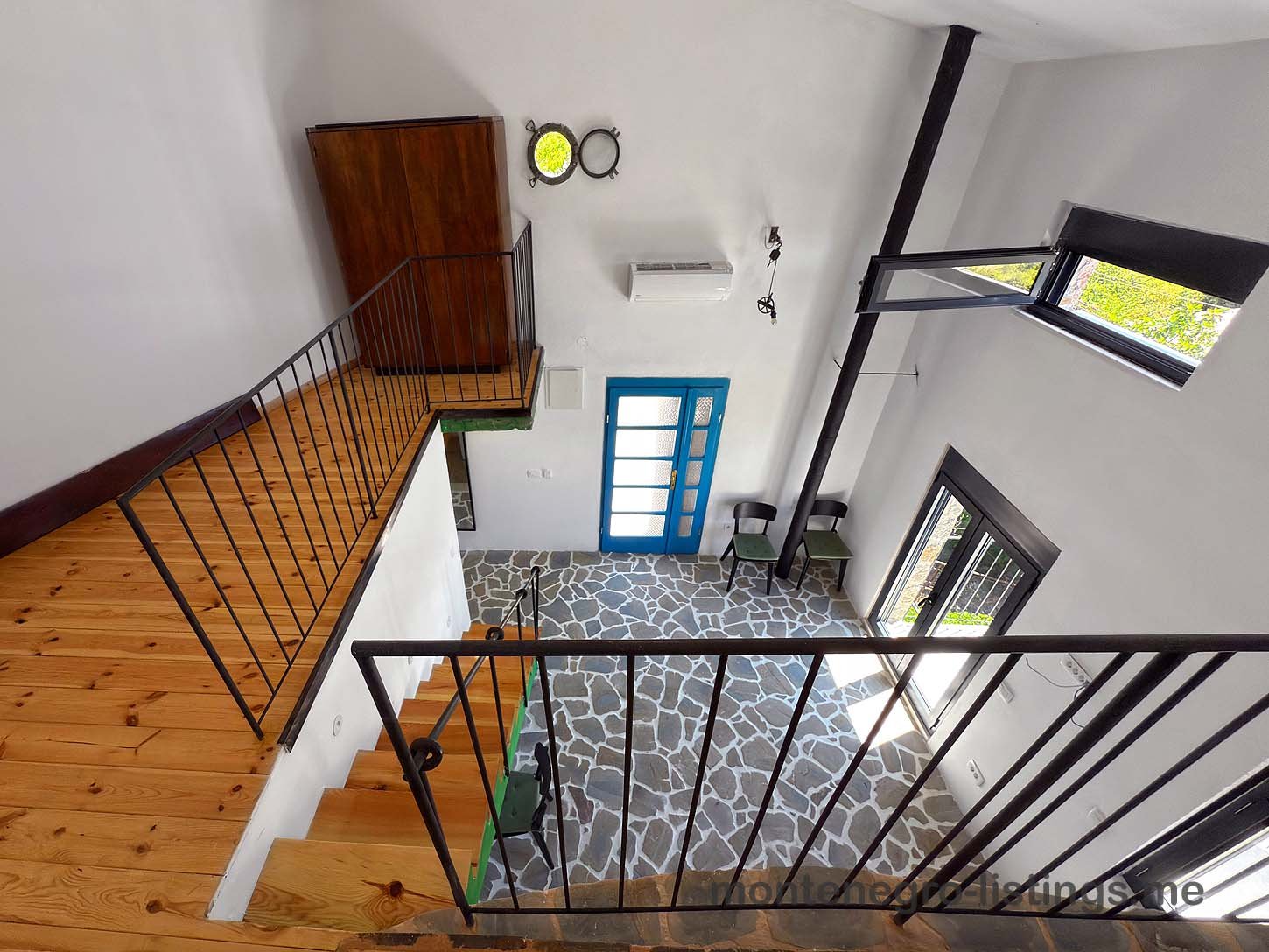 Listings for Sale - Modern open-concept living area in Ulcinj with wood stairs, stone flooring, large windows. Top Montenegro investment&mdash;immorenta.me by ekosphere doo.