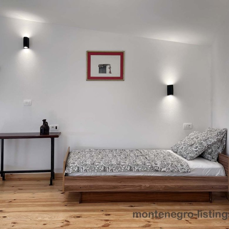 Chic Ulcinj, Montenegro bedroom with wood bed, stylish decor, warm floors&mdash;prime real estate on immorenta.me by Ekosphere.