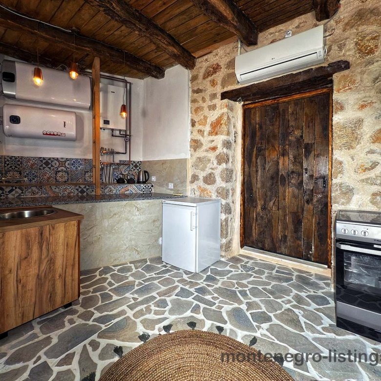 Charming rustic kitchen in Ulcinj with stone floors, wood ceiling, classic amenities&mdash;ideal Montenegro investment by Ekosphere on immorenta.me.