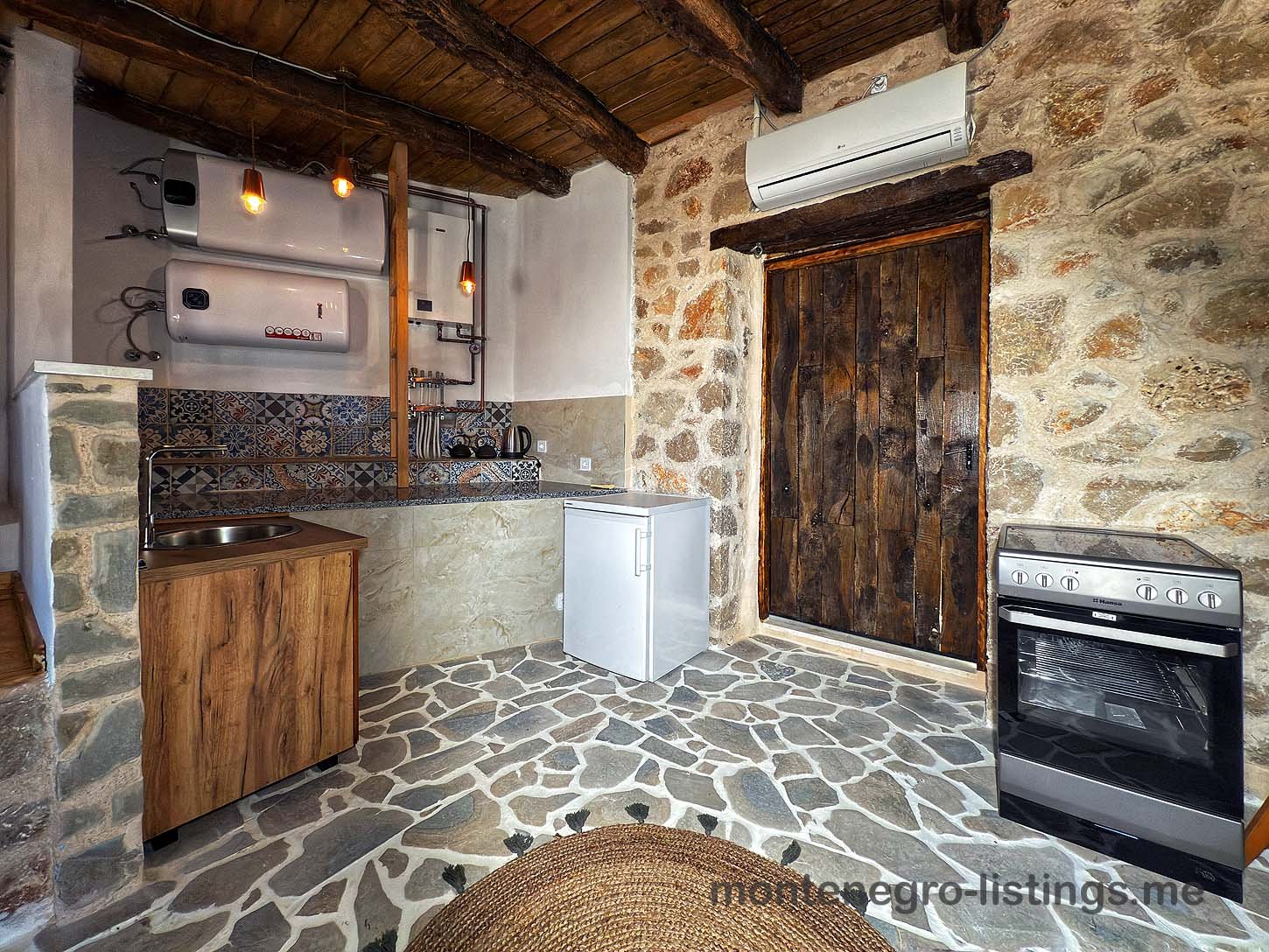Charming rustic kitchen in Ulcinj with stone floors, wood ceiling, classic amenities&mdash;ideal Montenegro investment by Ekosphere on immorenta.me.