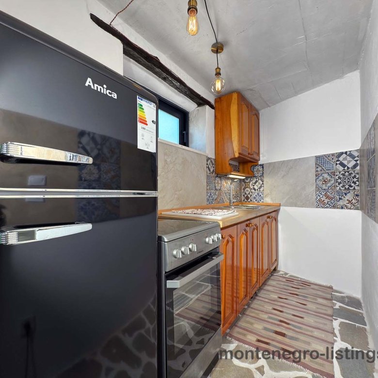 Modern Ulcinj kitchen: sleek Amica appliances, stylish tiles, wood cabinets&mdash;ideal Montenegro property. Listed on immorenta.me by ekosphere doo.