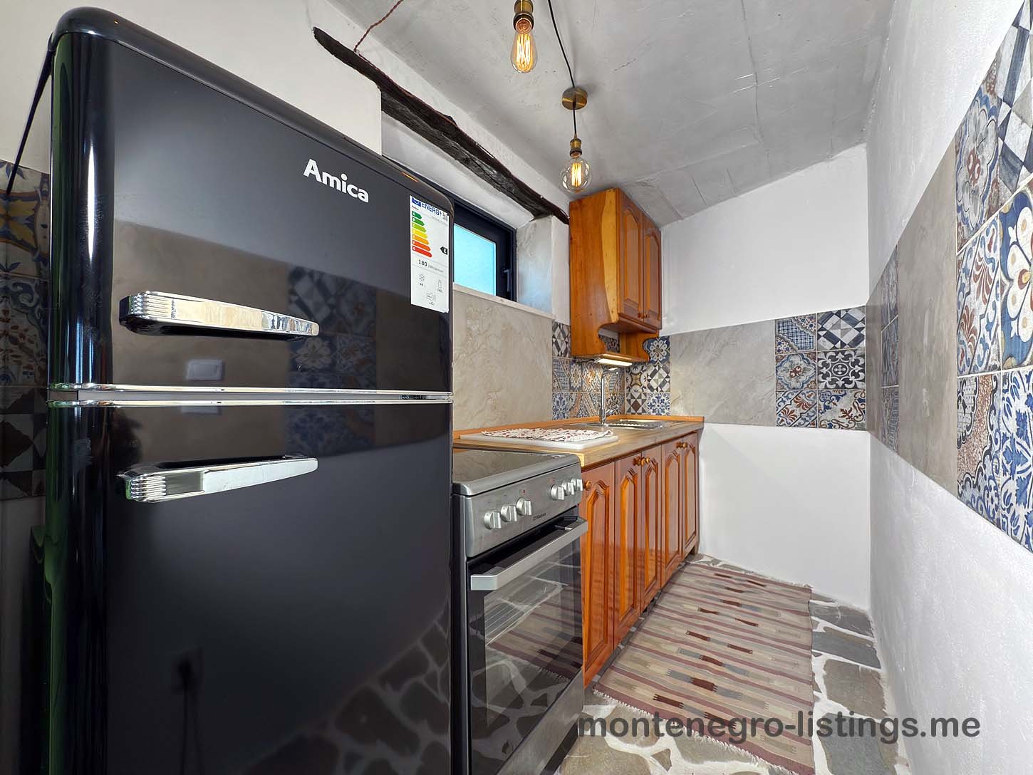 Modern Ulcinj kitchen: sleek Amica appliances, stylish tiles, wood cabinets&mdash;ideal Montenegro property. Listed on immorenta.me by ekosphere doo.