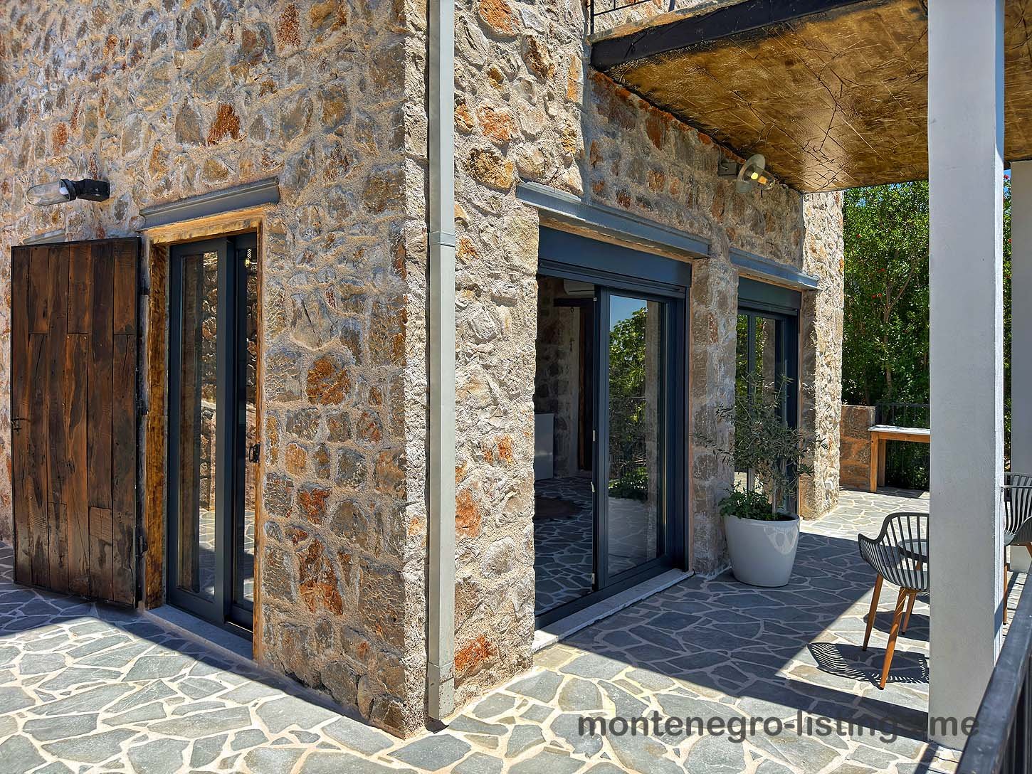 Modern Ulcinj stone corner home with sliding glass doors, patio, and mountain views&mdash;exclusive Ekosphere DOO investment via immorenta.me.