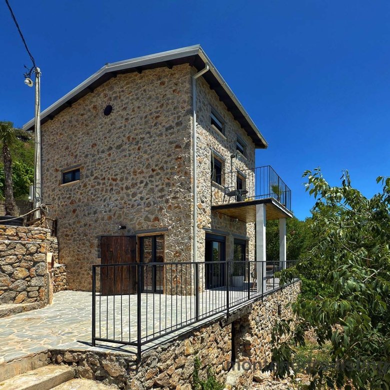 Discover this stunning two-story Ekosphere stone house in Ulcinj, Montenegro with large windows and a raised patio&mdash;exclusive at immorenta.me, a project by Ekosphere doo.