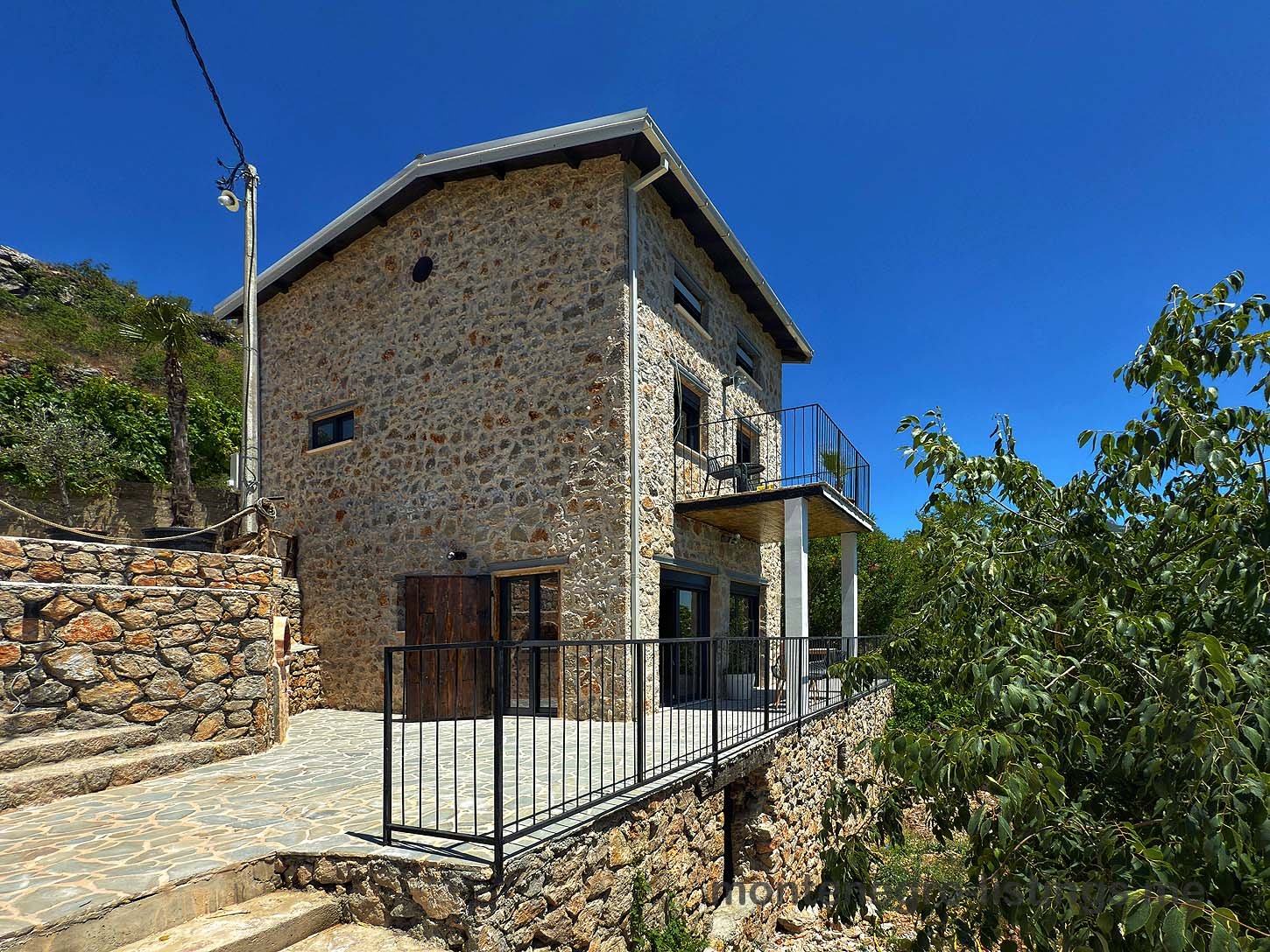 Discover this stunning two-story Ekosphere stone house in Ulcinj, Montenegro with large windows and a raised patio&mdash;exclusive at immorenta.me, a project by Ekosphere doo.