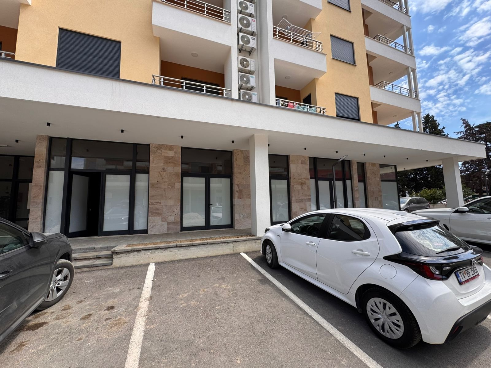 Modern multi-story building in Ulcinj, Montenegro with large windows and AC units&mdash;exclusive real estate by Ekosphere, immorenta.me.