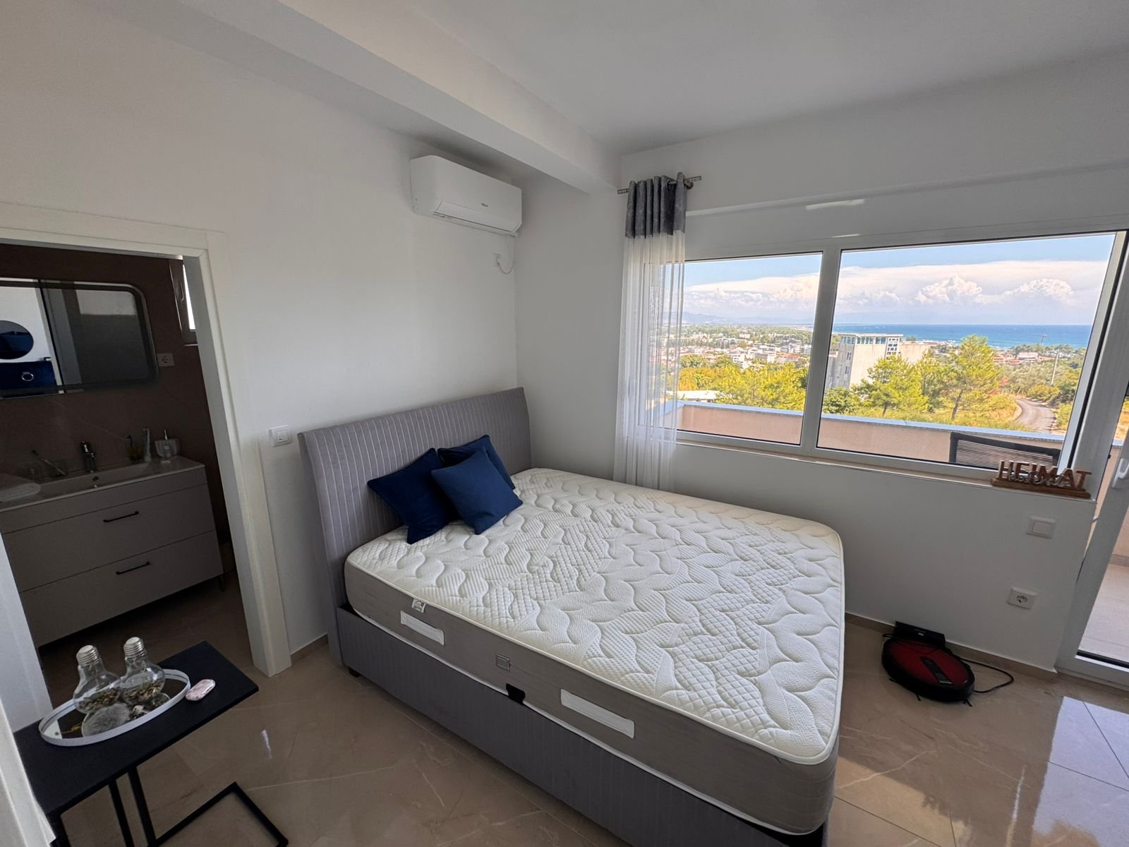 Bright Ulcinj bedroom with large window, sea and city views, ensuite bath. Premium investment at immorenta.me by ekosphere doo.