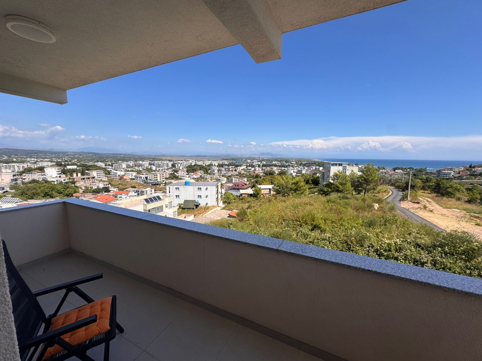 Premium Ulcinj Montenegro property: balcony with lush views, coastline, stylish seating. Top investment via immorenta.me/Ekosphere.