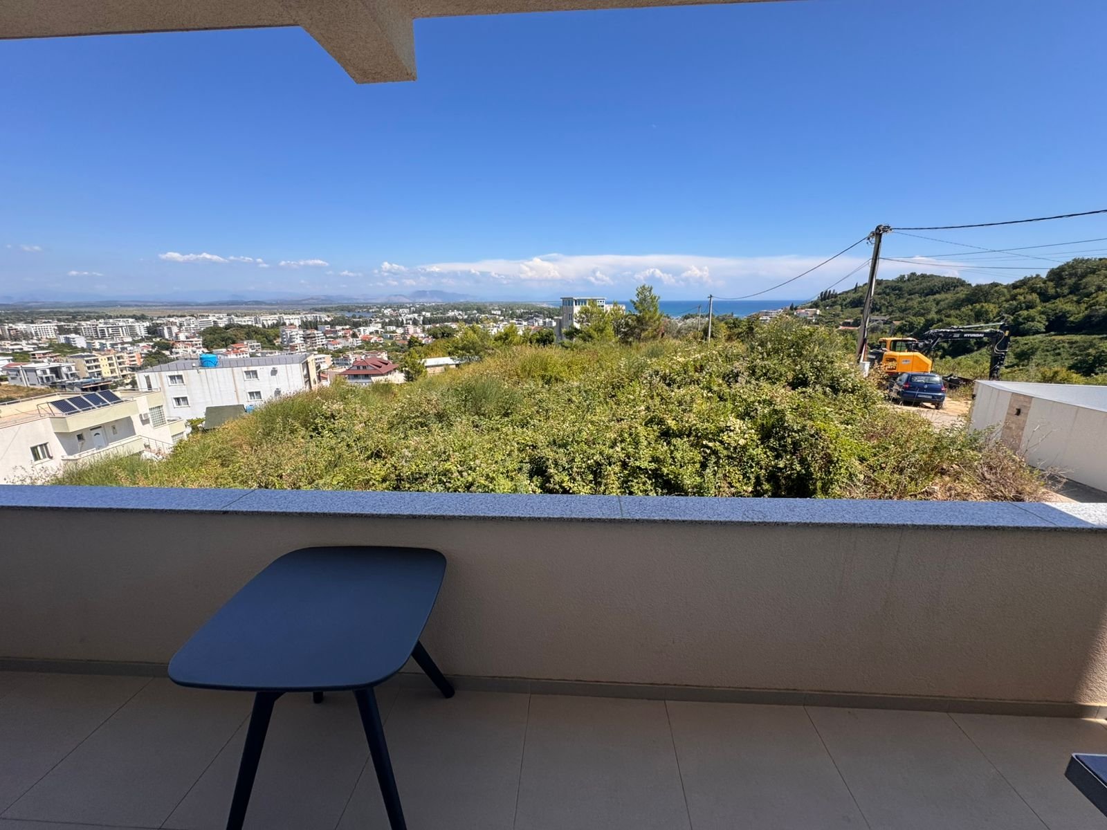 Stylish Ulcinj balcony with black table, green views, blue skies, cityscape&mdash;prime real estate via immorenta.me by ekosphere doo.