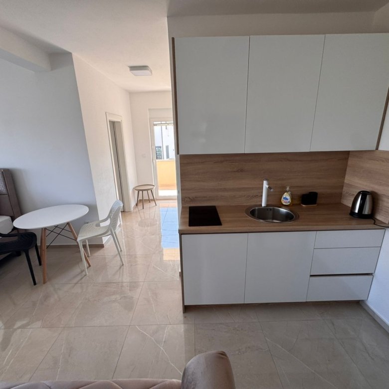 Modern Ulcinj studio: bright living, sleek kitchenette with white cabinets&mdash;exclusive investment via immorenta.me by Ekosphere.