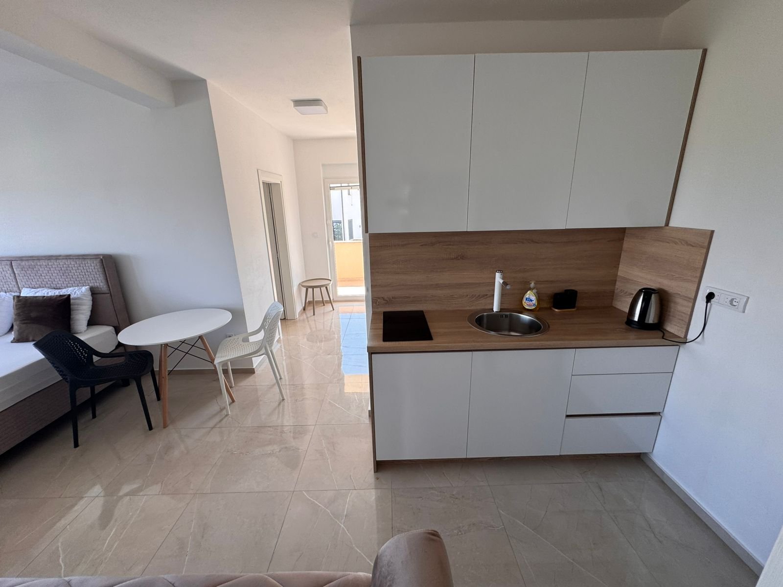 Modern Ulcinj studio: bright living, sleek kitchenette with white cabinets&mdash;exclusive investment via immorenta.me by Ekosphere.