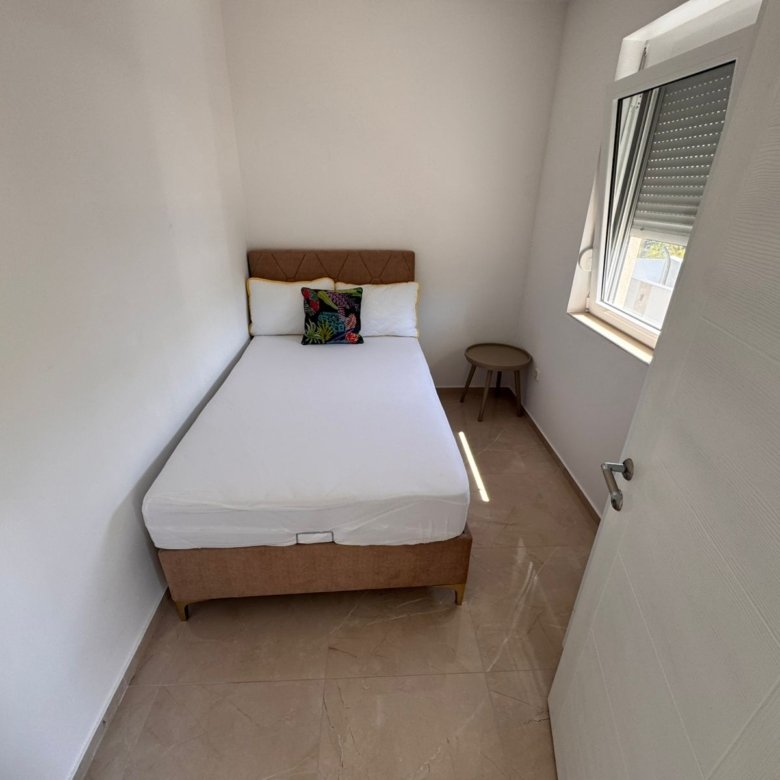 Chic Ulcinj apartment for sale with single bed, modern decor, and sunlit window&mdash;exclusive at immorenta.me by ekosphere doo.