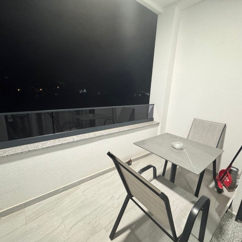 Elegant, clean Ulcinj balcony with table, chairs, and night views&mdash;ideal Montenegro investment. Exclusive on immorenta.me.