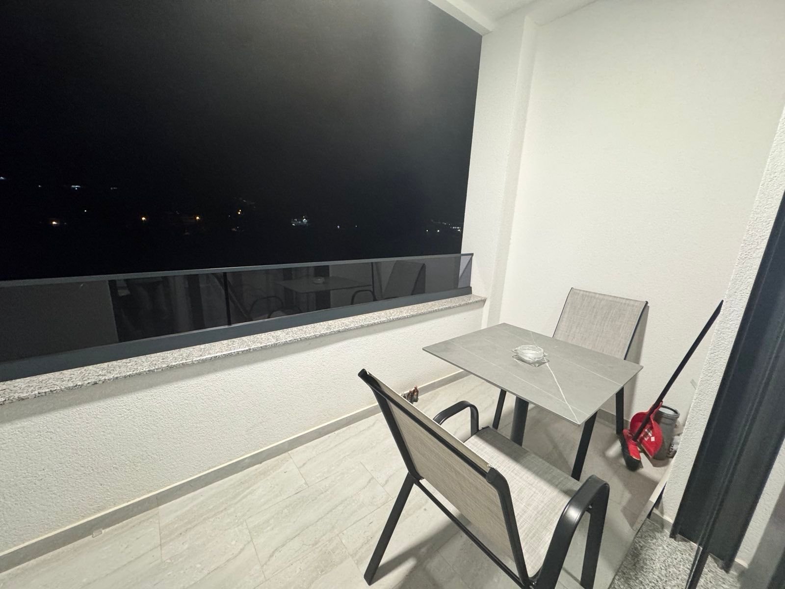 Elegant, clean Ulcinj balcony with table, chairs, and night views&mdash;ideal Montenegro investment. Exclusive on immorenta.me.