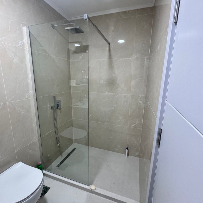 Elegant modern bathroom in Ulcinj, Montenegro with beige tiles, walk-in shower, premium fixtures. Exclusively at immorenta.me.