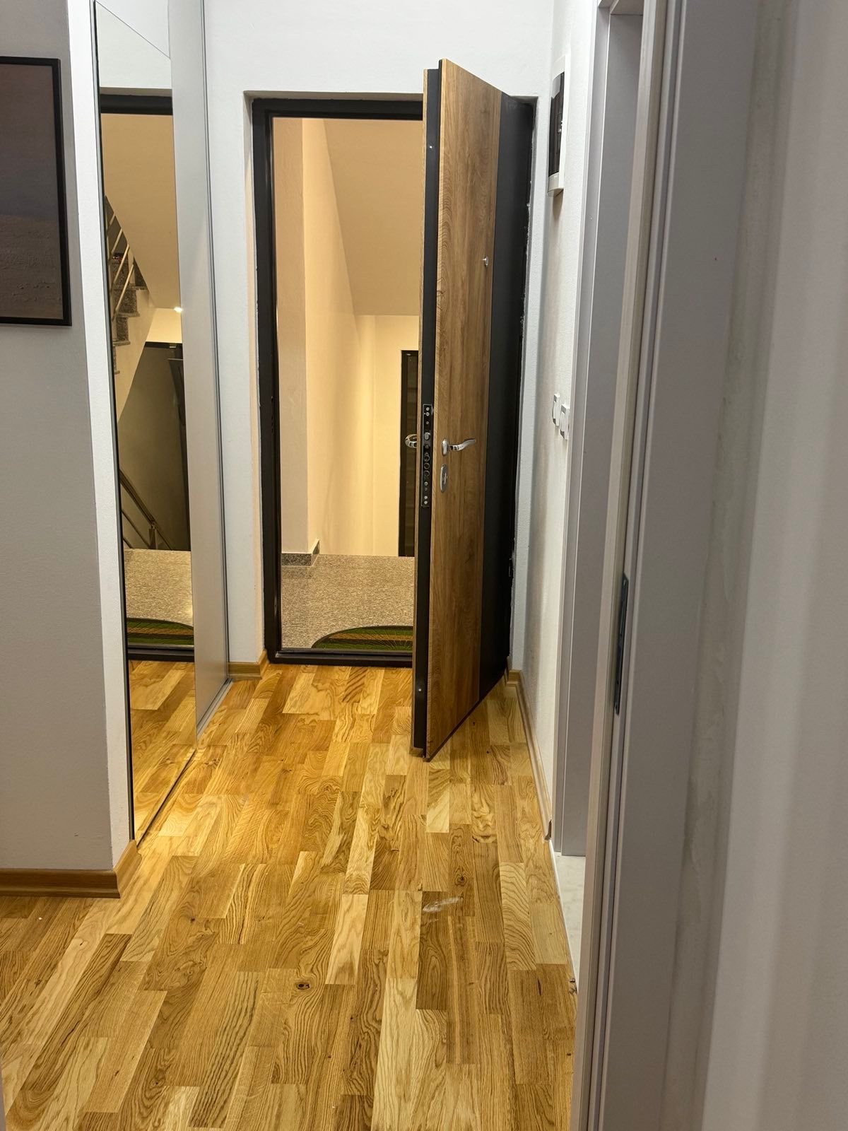 Elegant hallway with premium wooden floors, mirrored closet, stylish d&eacute;cor; leads to spacious carpeted corridor and stairs&mdash;ideal Ulcinj investment. Presented by immorenta.me, a project of ekosphere doo.
