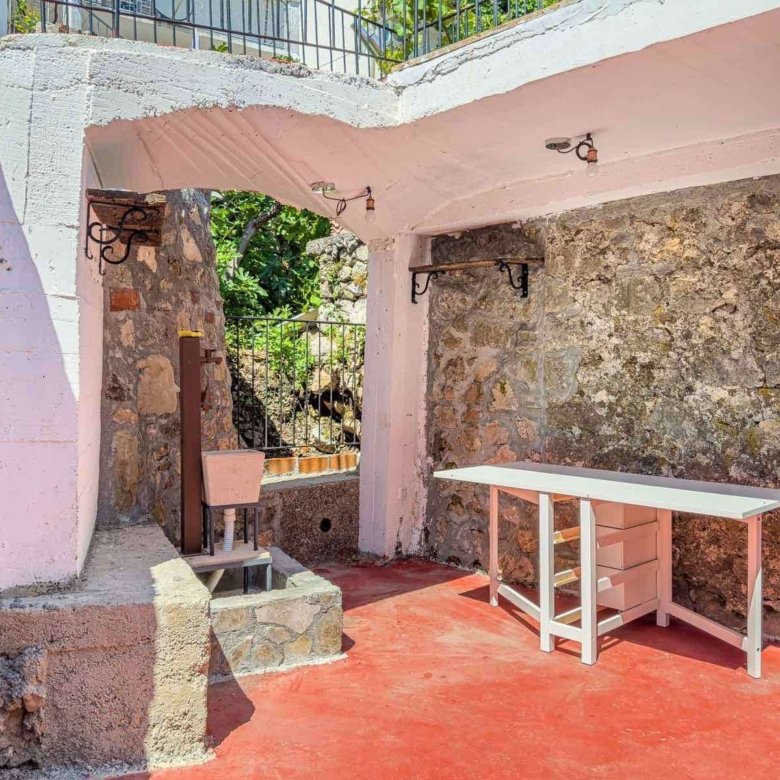 Stunning shaded outdoor area in Ulcinj with stone walls, red flooring, and stylish fixtures&mdash;ideal Montenegro investment by ekosphere doo.