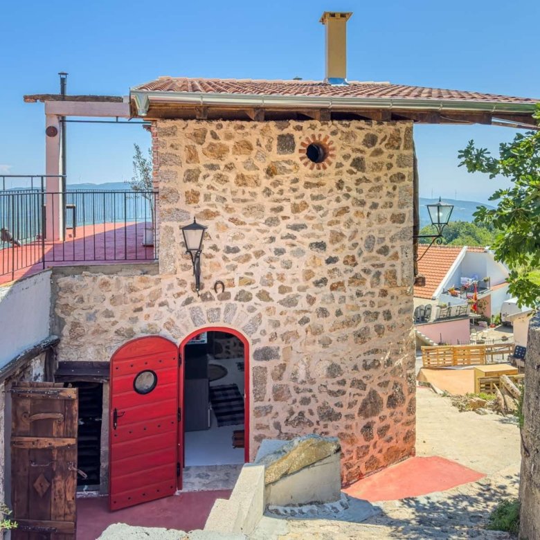 Charming stone property in Ulcinj, Montenegro with red arched doors, hillside views; exclusive at immorenta.me by ekosphere doo.