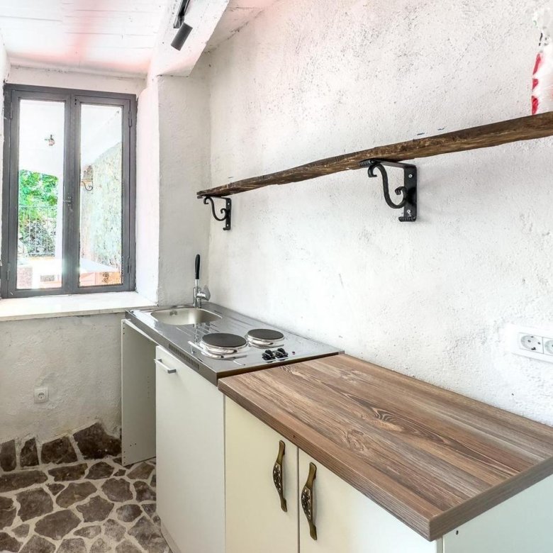 Charming Ulcinj kitchen: stone floors, white textured walls, bright window. Ideal investment via immorenta.me by ekosphere doo.