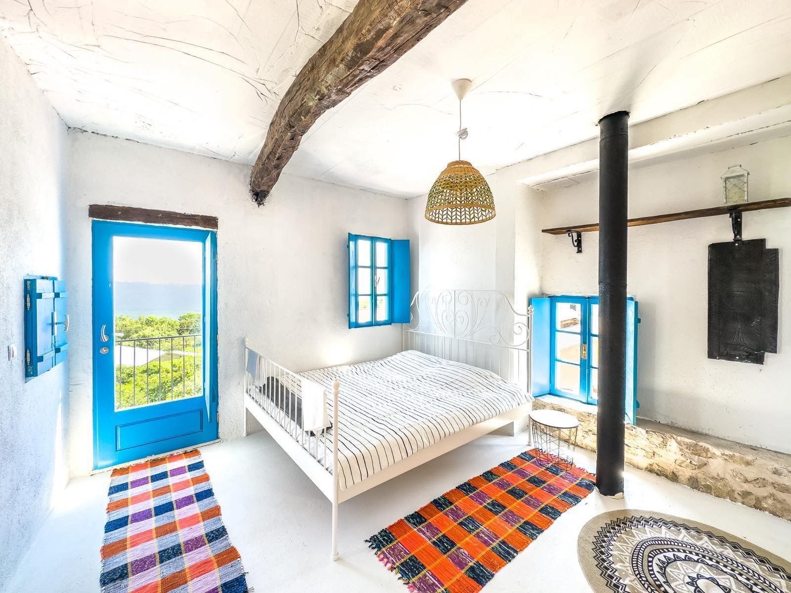 Listings for Sale - Spacious Ulcinj bedroom with white walls, blue windows, double bed, stove & lush views. Rare Montenegro investment&mdash;see immorenta.me by ekosphere doo.