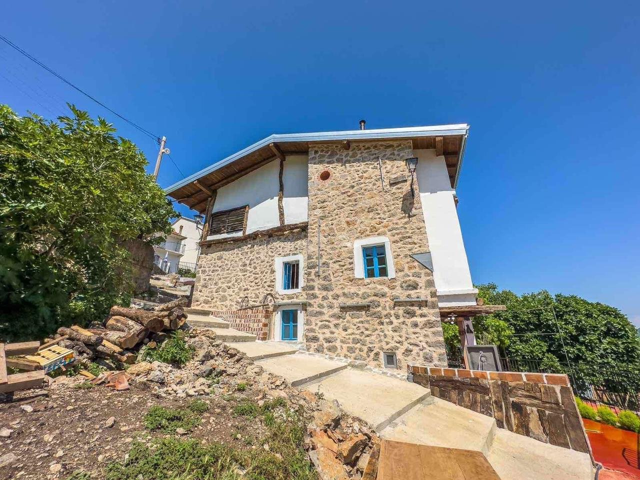 Charming stone house with blue windows, set on elevated terrain in Ulcinj. Ideal Montenegro property investment. Montenegro-listings.me by Ekosphere DOO.