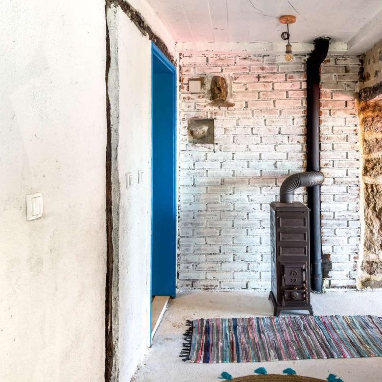 Charming Ulcinj retreat with whitewashed brick walls, wood stove, blue door & stone accents. Exclusive at immorenta.me by ekosphere doo.