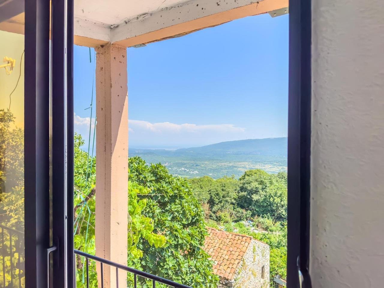 Stunning Ulcinj Montenegro property: balcony with scenic views of lush greenery, red-tiled roof, rolling hills & blue sky. Invest now&mdash;immorenta.me by ekosphere doo.