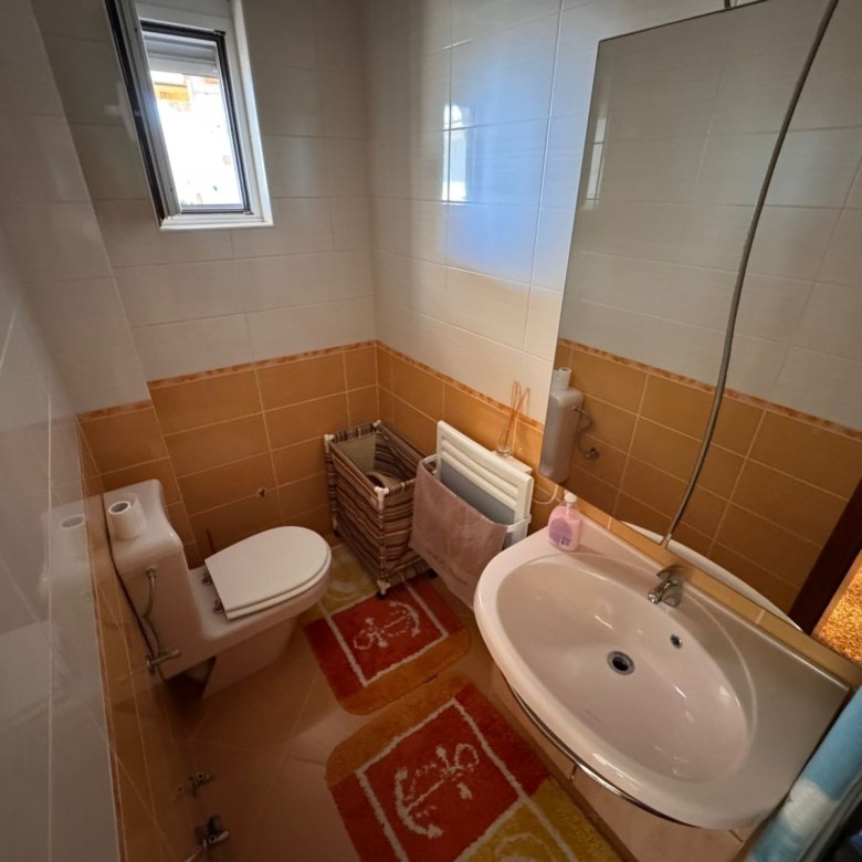 Stylish Ulcinj bathroom: modern white sink, mirror, bright window, quality tiling. Exclusive at immorenta.me by ekosphere doo.