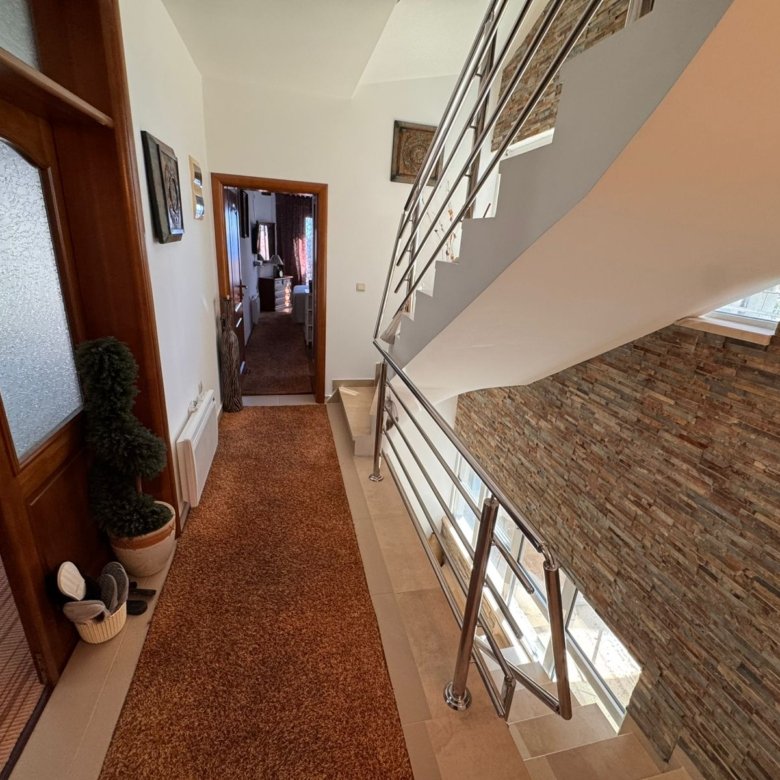 Elegant Ulcinj hallway with designer d&eacute;cor, modern stairway, and sunlit open room&mdash;prime Montenegro real estate by ekosphere doo.