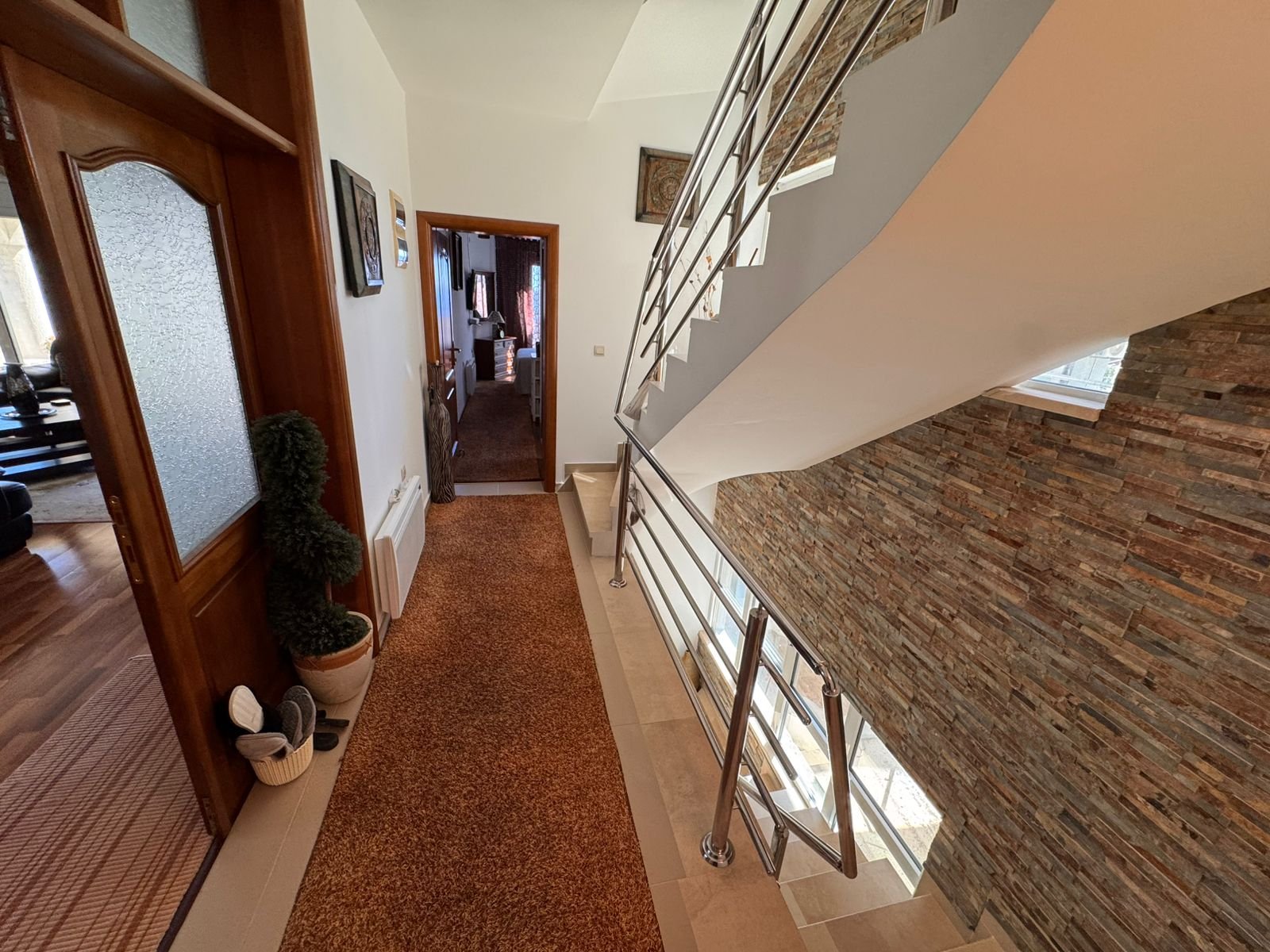 Elegant Ulcinj hallway with designer d&eacute;cor, modern stairway, and sunlit open room&mdash;prime Montenegro real estate by ekosphere doo.