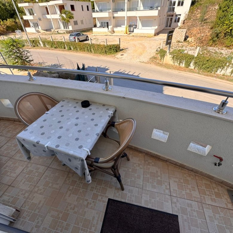 Charming Ulcinj balcony with modern tiles, metal railing, and outdoor seating. Invest in Montenegro real estate at immorenta.me &ndash; a project of ekosphere doo.