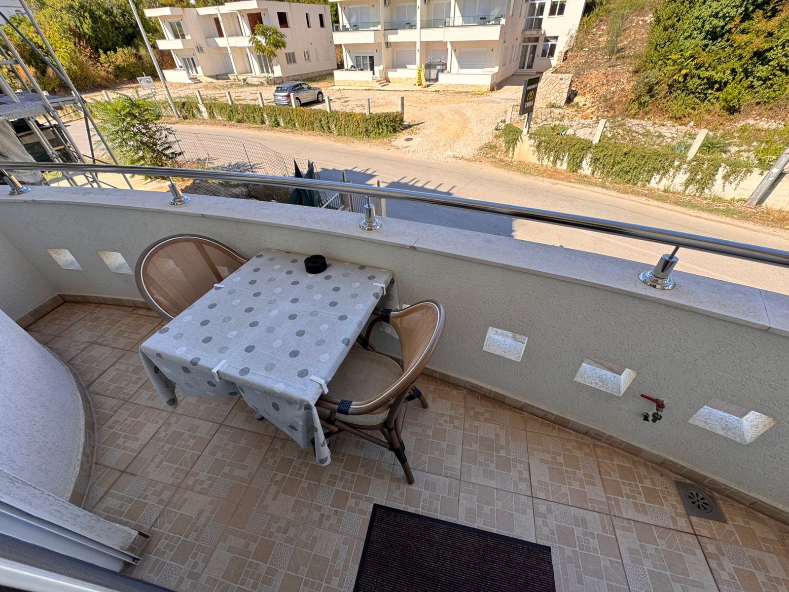 Charming Ulcinj balcony with modern tiles, metal railing, and outdoor seating. Invest in Montenegro real estate at immorenta.me &ndash; a project of ekosphere doo.