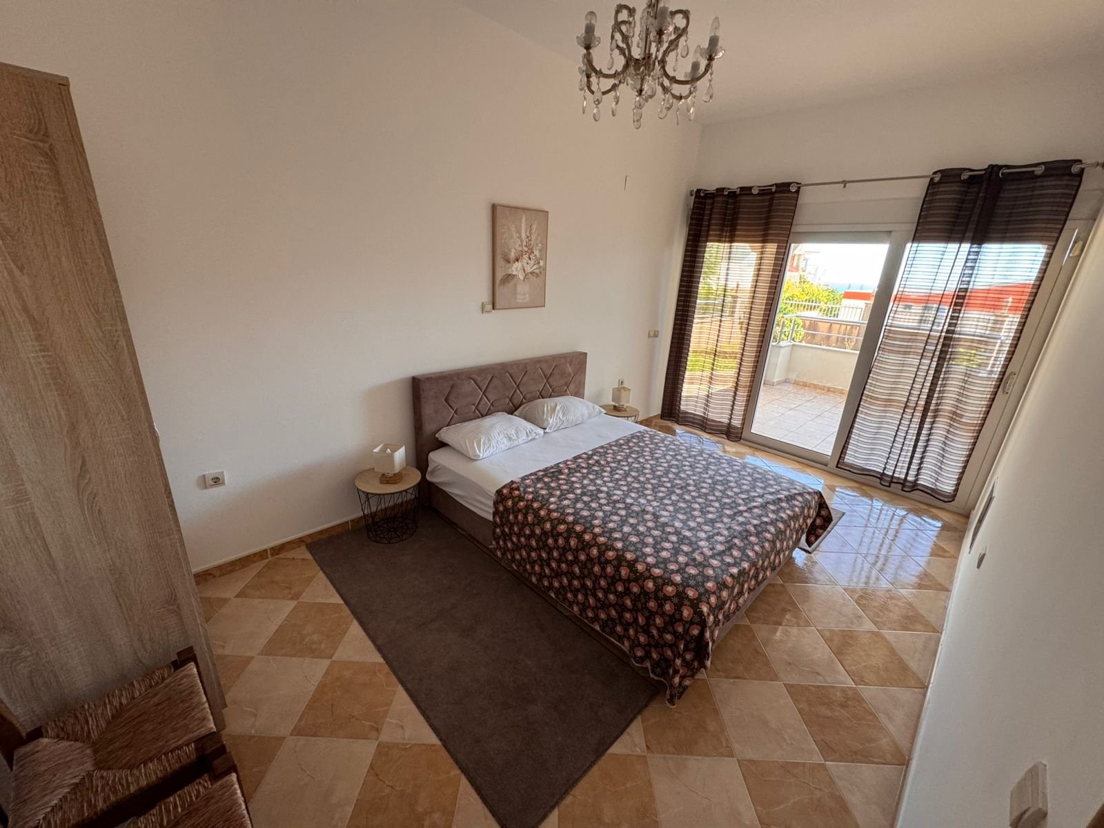 Elegant Ulcinj bedroom: double bed, nightstands, chandelier, checkered floors, balcony with views&mdash;exclusive at immorenta.me by ekosphere doo.