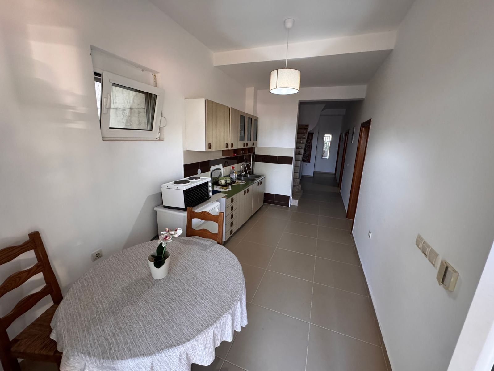 Charming Ulcinj kitchen with a modern layout, quality cabinets, dining nook, and bright hallway &mdash; exclusive at immorenta.me by ekosphere doo.