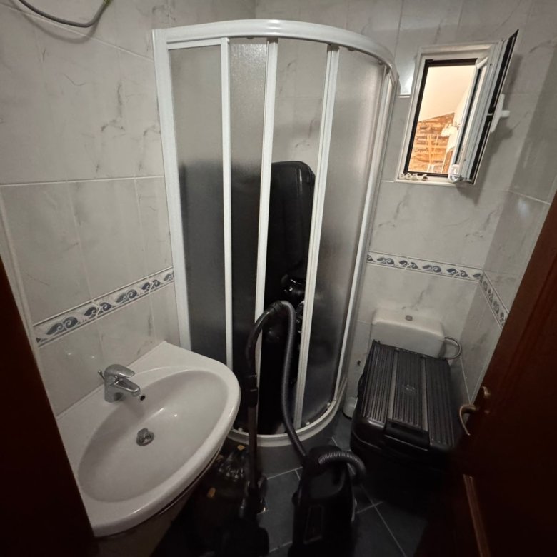 Modern Ulcinj bathroom with corner shower, open window, white-blue tiles; perfect buy-to-let on immorenta.me by ekosphere doo.