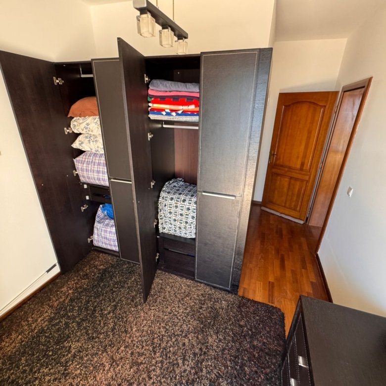 Modern dark wood wardrobe with organized storage in Ulcinj property; stylish flooring, premium interiors&mdash;exclusive at immorenta.me by Ekosphere DOO.