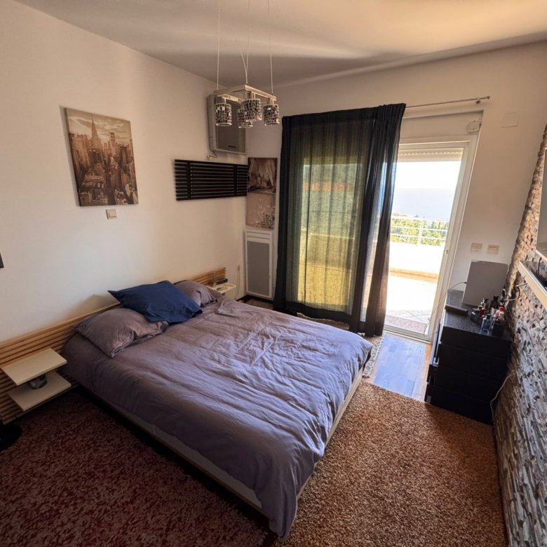 Modern Ulcinj bedroom with gray double bed, balcony view, TV, and desk&mdash;ideal Montenegro real estate from ekosphere doo.