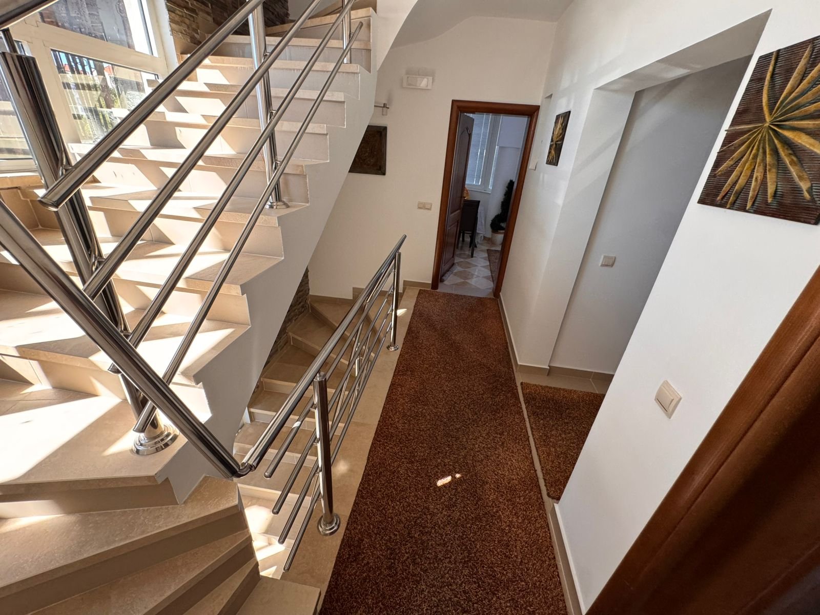 Showcasing a sunlit Ulcinj hallway with modern beige stairs, premium finishes, and investment potential via immorenta.me by ekosphere doo.