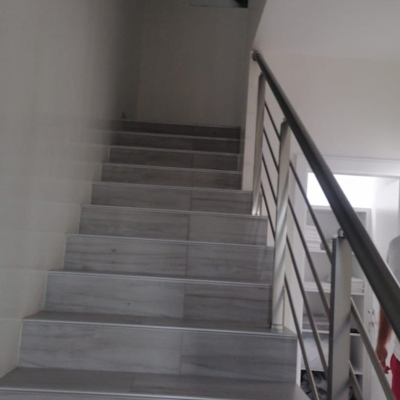 Modern staircase with light gray steps and sleek handrail, bright interior&mdash;premium Ulcinj property by immorenta.me/Ekosphere doo.