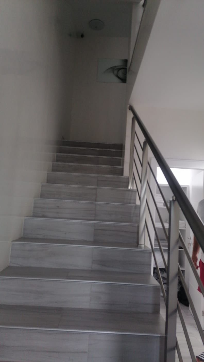 Modern staircase with light gray steps and sleek handrail, bright interior&mdash;premium Ulcinj property by immorenta.me/Ekosphere doo.