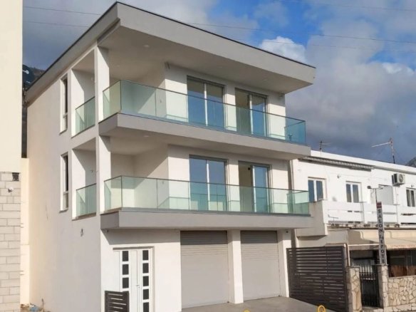 Luxurious three-story white residence in Ulcinj with glass balconies, double garage, prime investment, offered by immorenta.me.