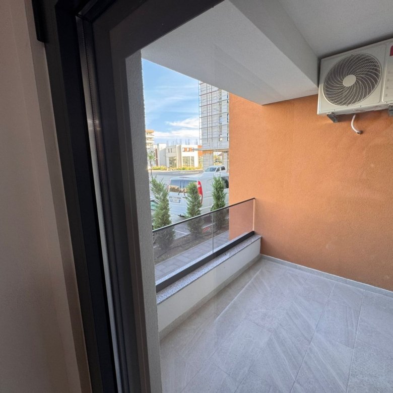 Modern tiled balcony in Ulcinj with glass railing, AC, and urban views&mdash;prime Montenegro real estate by ekosphere doo on immorenta.me.