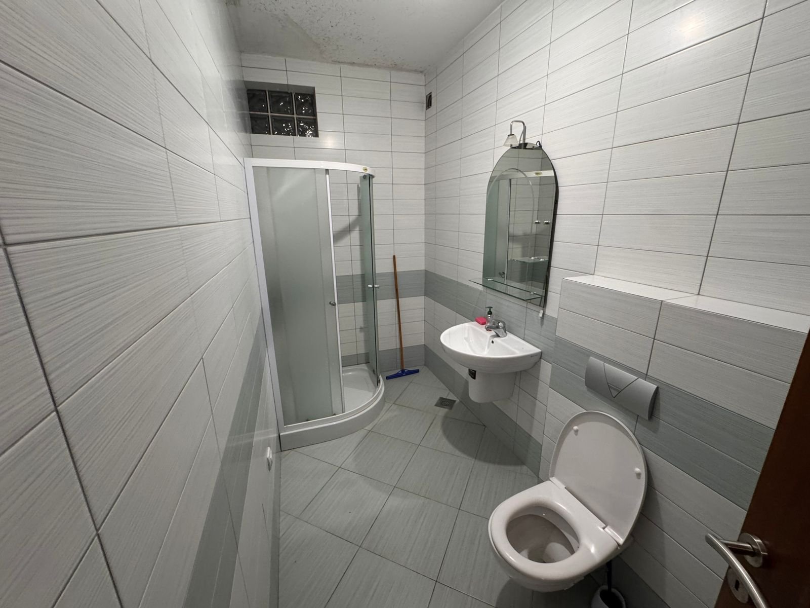 Modern gray-tiled bathroom with glass shower, wall-mount sink, and premium fixtures&mdash;exclusive Ulcinj investment via immorenta.me by ekosphere doo.