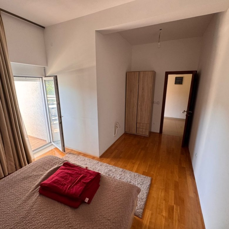Spacious Ulcinj bedroom with double bed, balcony access, modern wardrobe, and quality wooden floors&mdash;exclusive at immorenta.me by ekosphere doo.