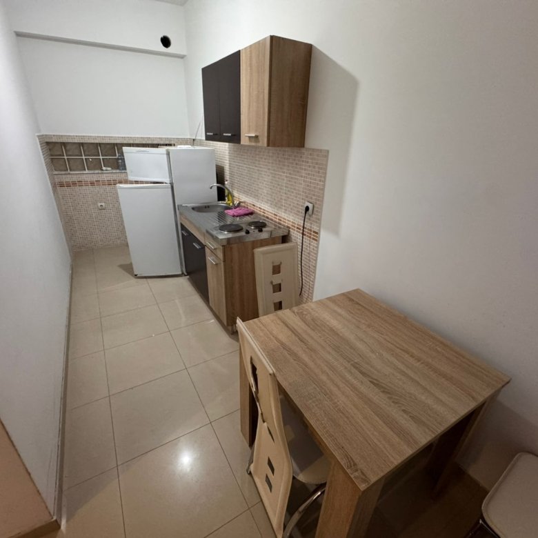 Bright, well-equipped Ulcinj kitchen with light wood cabinetry, modern appliances, and dining area&mdash;perfect real estate investment. Montenegro-listings.me by ekosphere doo.